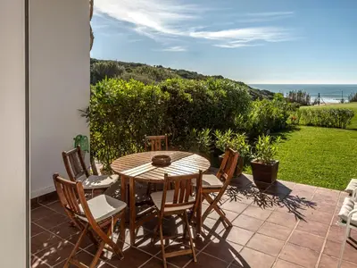 a table and chairs on a patio with a view of the ocean at Villa Cristina by Interhome in Conil de la Frontera