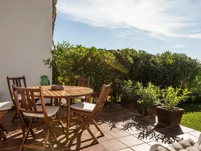 a wooden table and chairs on a patio with plants at Villa Cristina by Interhome in Conil de la Frontera