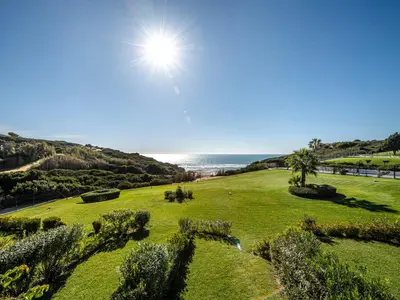 a field of grass with the ocean in the background at Villa Cristina by Interhome in Conil de la Frontera