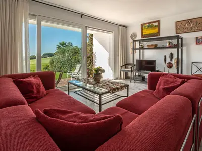a living room with a red couch and a table at Villa Cristina by Interhome in Conil de la Frontera