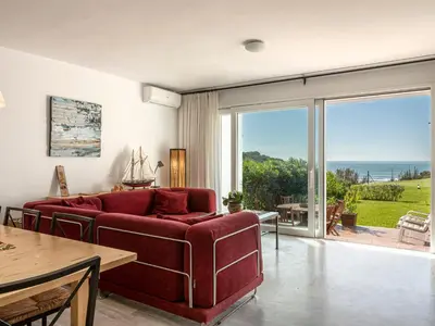 a living room with a red couch and a view of the ocean at Villa Cristina by Interhome in Conil de la Frontera