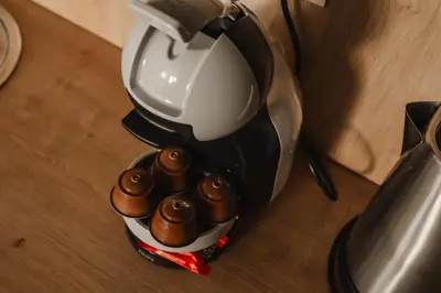 a coffee maker with a bunch of cupcakes at esZentrico Suites Jerez in Jerez de la Frontera