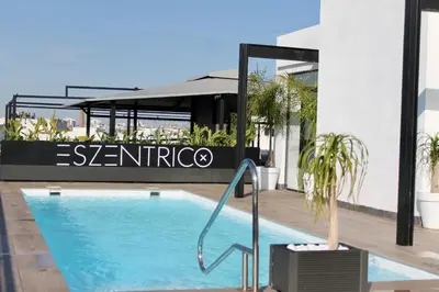 a swimming pool in front of a building at esZentrico Suites Jerez in Jerez de la Frontera