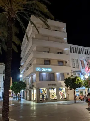 a building with a store in front of it at night at Allo Apartments Plaza Arenal Centro 2 Habitaciones in Jerez de la Frontera