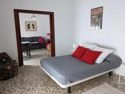 a bedroom with a bed with red pillows on it at Allo Apartments Plaza Arenal Centro 2 Habitaciones in Jerez de la Frontera