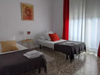 a hotel room with two beds and a couch at Allo Apartments Plaza Arenal Centro 2 Habitaciones in Jerez de la Frontera