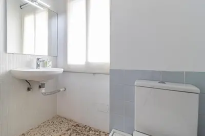a bathroom with a sink and a toilet and a mirror at Allo Apartments Plaza Arenal Centro 2 Habitaciones in Jerez de la Frontera