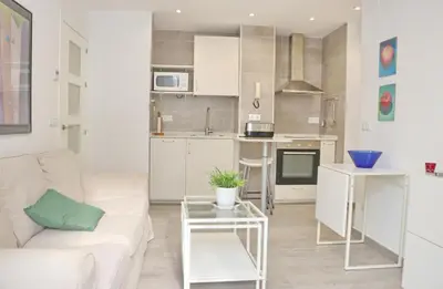 a white living room with a couch and a table at Apartamento Madrid in Cádiz