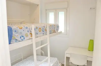 a bunk bed in a room with a desk and a chair at Apartamento Madrid in Cádiz