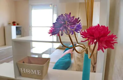 two flowers in a blue vase on a table at Apartamento Angel in San Fernando