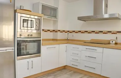 a kitchen with white cabinets and stainless steel appliances at Apartamento Angel in San Fernando