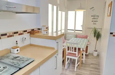 a kitchen with a counter and a table and chairs at Apartamento Angel in San Fernando