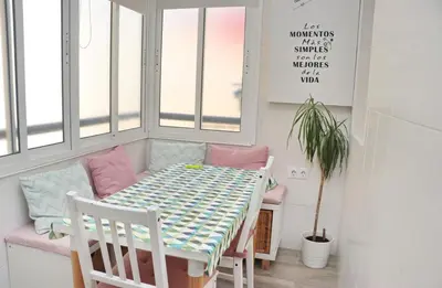 a dining room with a table and chairs and windows at Apartamento Angel in San Fernando