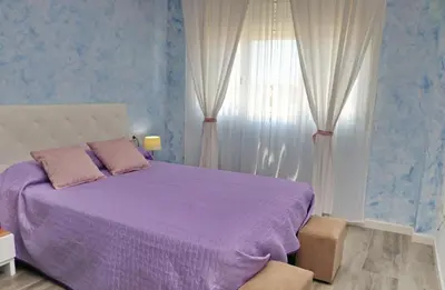 a bedroom with a purple bed and a window at Apartamento Angel in San Fernando