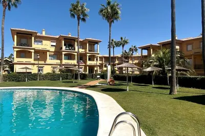 a resort with a swimming pool in front of a building at Novo Sancti Petri, La Barrosa, 2 Beds Room Apartamento by Chiclana Dreams in Chiclana de la Frontera
