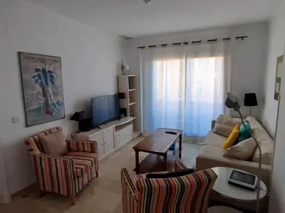 a living room with a couch and a tv at Novo Sancti Petri, La Barrosa, 2 Beds Room Apartamento by Chiclana Dreams in Chiclana de la Frontera