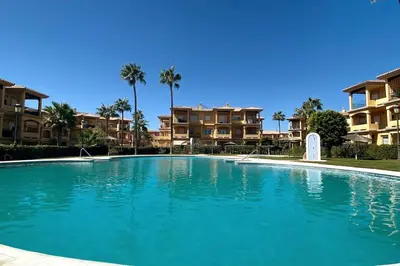 a large swimming pool in front of some apartments at Novo Sancti Petri, La Barrosa, 2 Beds Room Apartamento by Chiclana Dreams in Chiclana de la Frontera