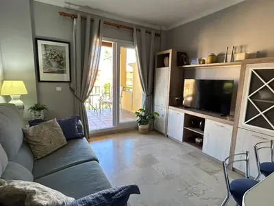 a living room with a couch and a television at Apartamento excelente ubicación en Novo Sancti Petri By Chiclana Dreams in Chiclana de la Frontera
