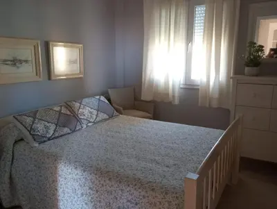 a bedroom with a bed and a chair and a window at Apartamento excelente ubicación en Novo Sancti Petri By Chiclana Dreams in Chiclana de la Frontera