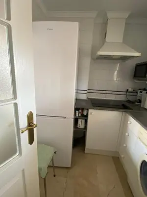 a kitchen with a white refrigerator in a room at Apartamento excelente ubicación en Novo Sancti Petri By Chiclana Dreams in Chiclana de la Frontera