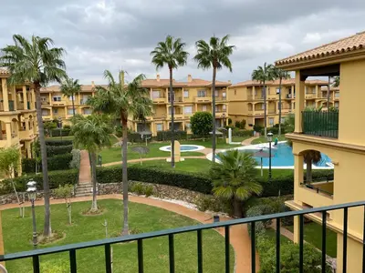 a view from the balcony of a resort with a pool and palm trees at Apartamento excelente ubicación en Novo Sancti Petri By Chiclana Dreams in Chiclana de la Frontera