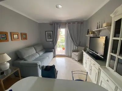 a living room with a couch and a tv at Apartamento excelente ubicación en Novo Sancti Petri By Chiclana Dreams in Chiclana de la Frontera