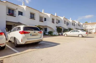 a white car parked in a parking lot in front of a building at Laja Bermeja, piscina y primera línea de La Barrosa in Chiclana de la Frontera