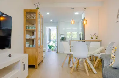 a kitchen and living room with a table and chairs at Laja Bermeja, piscina y primera línea de La Barrosa in Chiclana de la Frontera