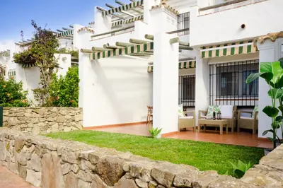 a white house with a stone wall at Laja Bermeja, piscina y primera línea de La Barrosa in Chiclana de la Frontera