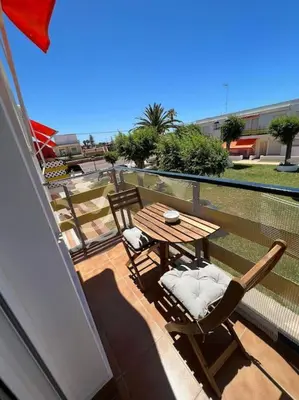 a balcony with a table and chairs on a roof at Precioso Apto con vistas al Parque Nacional Doñana in Chipiona