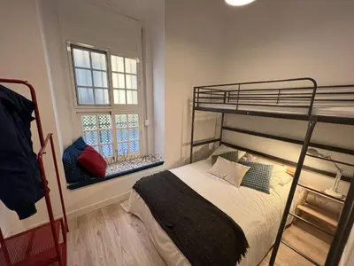 a bedroom with a bunk bed and a window at Patiovecino Apartment Centro de Cádiz in Cádiz