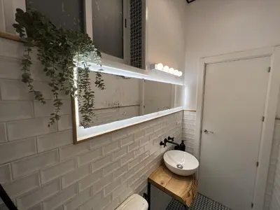 a bathroom with a sink and a toilet and a mirror at Patiovecino Apartment Centro de Cádiz in Cádiz