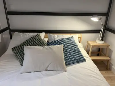 a bed with pillows and a black and white headboard at Patiovecino Apartment Centro de Cádiz in Cádiz