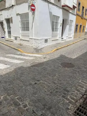 a street in front of a building with a stop sign at Apartamento Veracruz in Rota