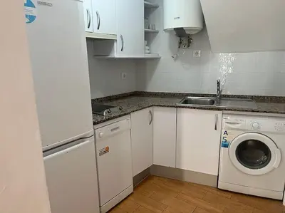 a kitchen with white cabinets and a washing machine at Apartamento Veracruz in Rota