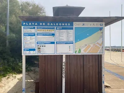 a large sign at the beach with a boardwalk at Apartamento a unos pasos de la Playa (Rota) in Rota