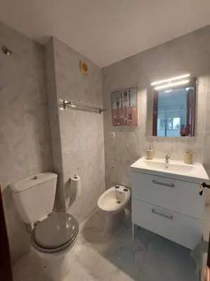 a bathroom with a toilet and a sink at Amplio apartamento junto a la Playa Victoria in Cádiz