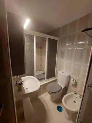 a bathroom with a toilet and a bidet and a sink at Amplio apartamento junto a la Playa Victoria in Cádiz