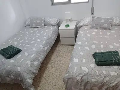two beds sitting next to each other in a bedroom at Amplio apartamento junto a la Playa Victoria in Cádiz