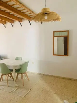 a room with a table and chairs and a mirror at Piso coqueto céntrico en Jerez (San Miguel) in Jerez de la Frontera