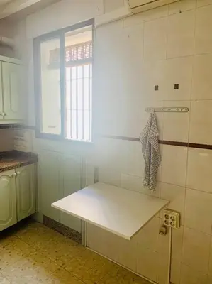 a kitchen with a white counter and a window at Piso coqueto céntrico en Jerez (San Miguel) in Jerez de la Frontera