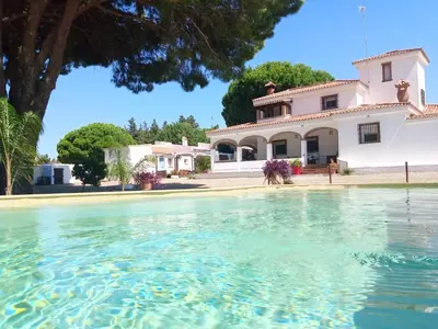 a house with a pool of water in front of it at CÁDIZ - GANESHA acogedor apartamento en Chiclana de la Frontera, España in Chiclana de la Frontera