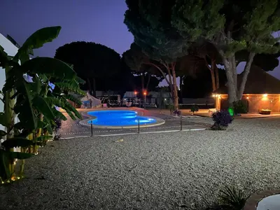 a swimming pool in a yard at night at CÁDIZ - GANESHA acogedor apartamento en Chiclana de la Frontera, España in Chiclana de la Frontera