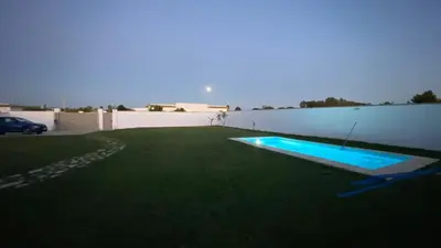 a backyard with a swimming pool in the grass at Casa Costa Ecologica y de Design con Piscina, Jardin y Parking in Chiclana de la Frontera
