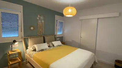 a bedroom with a bed with a yellow bedspread at Casa Costa Ecologica y de Design con Piscina, Jardin y Parking in Chiclana de la Frontera