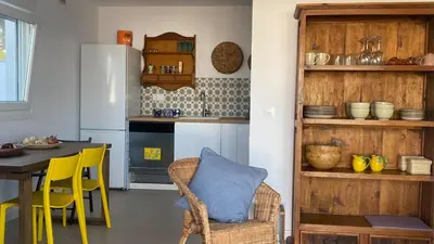 a kitchen with a table and yellow chairs at Casa Costa Ecologica y de Design con Piscina, Jardin y Parking in Chiclana de la Frontera