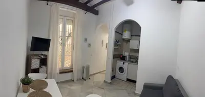 a living room with a couch and a table and a kitchen at Apartamento Casa Palacio 1890. in El Puerto de Santa María