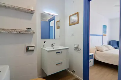 a bathroom with a sink and a mirror and a bed at AranPe PLAYA CÁDIZ in Cádiz