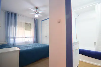 a bedroom with a blue bed and a ceiling fan at AranPe PLAYA CÁDIZ in Cádiz