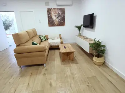 a living room with a couch and a tv at Sumatra Chalet in Chiclana de la Frontera